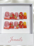 Pink orange red ombre press-on nails with 3D red flowers, gold butterfly charm and yellow polka dot accent nail